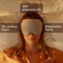 Load image into Gallery viewer, A woman lying in bed wearing a beige sleep mask, with text overlays highlighting features: '360° adaptable fit', '3D contour foam', and 'Breathable fabric'.
