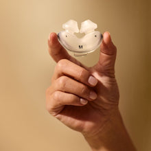 Load image into Gallery viewer, Hand holding a white dental model against a beige background
